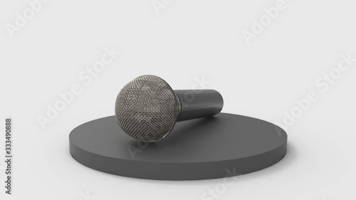 loopable rotating simple microphone on black podium with gray wall as background.