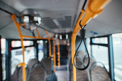 Close-up of a handle inside of empty bus during COVID-19 pandemic.