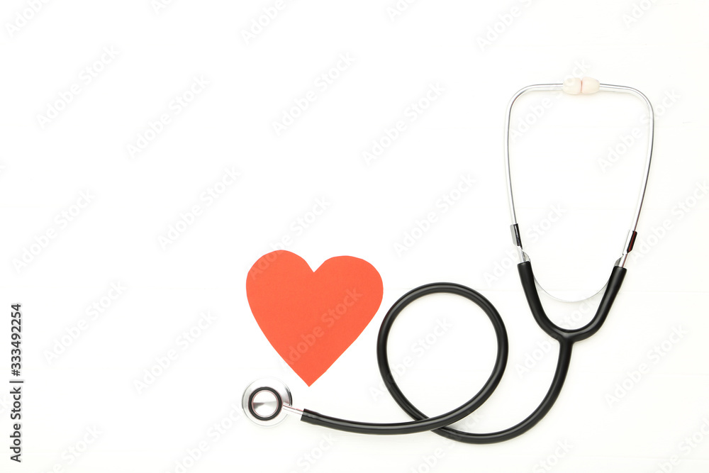 Stethoscope with red paper heart on white background Stethoscope with red paper heart on white background