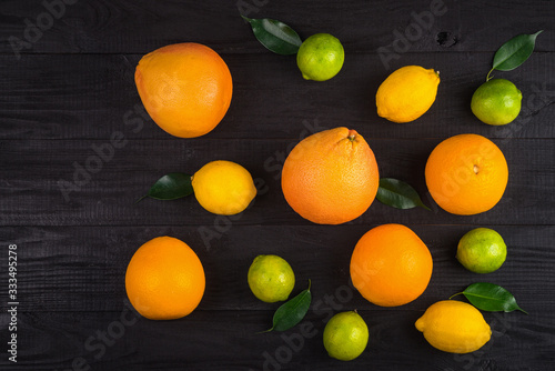 grapefruit, oranges, lemons and lime on the brown table. background