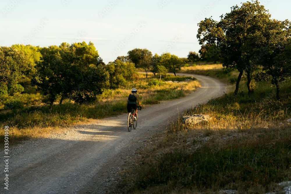 Female cyclist commutes home from work on gravel