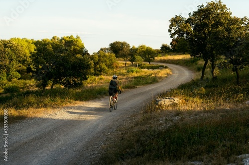 Female cyclist commutes home from work on gravel