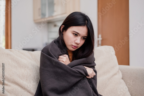 Slika na platnu Portrait of a shivering and sick flu young woman asian at home