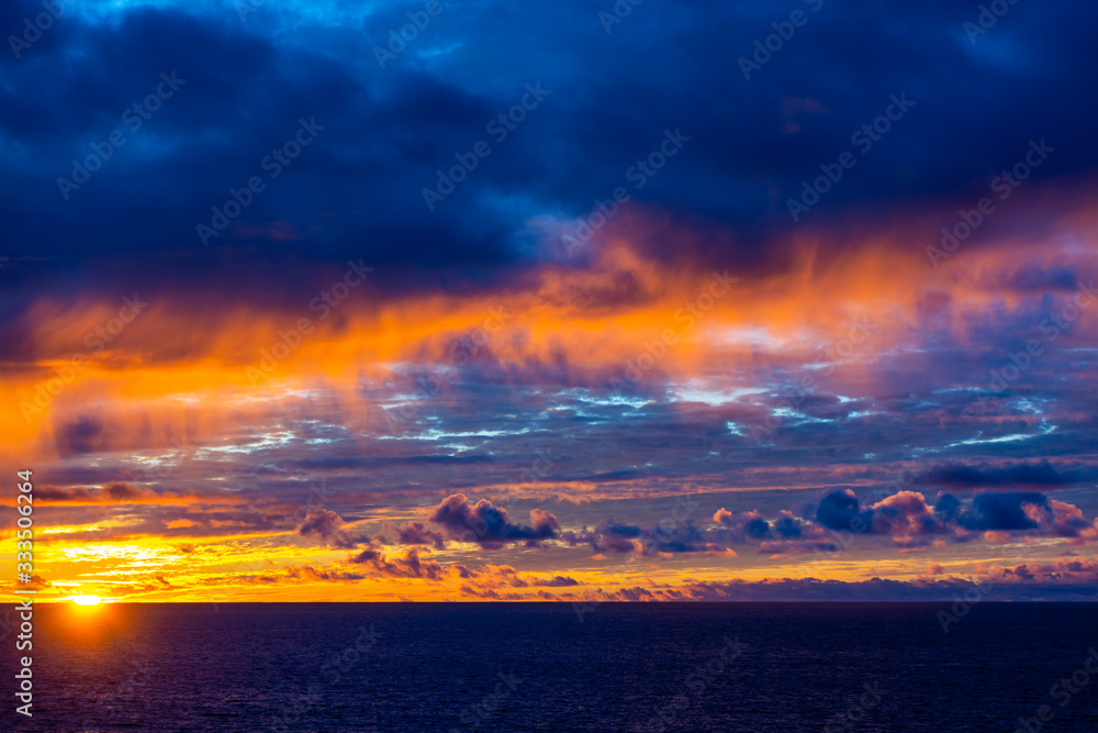 Amazing sunset with colorful clouds and dark ocean water, nature background