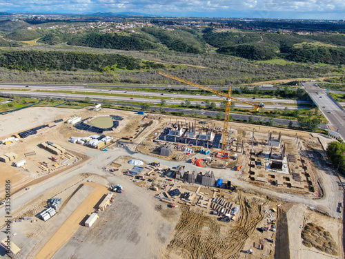 Aerial view of investors and contractors on construction site with crane. New construction site with crane and building materials. San Diego, California, USA. March, 26th, 2020 