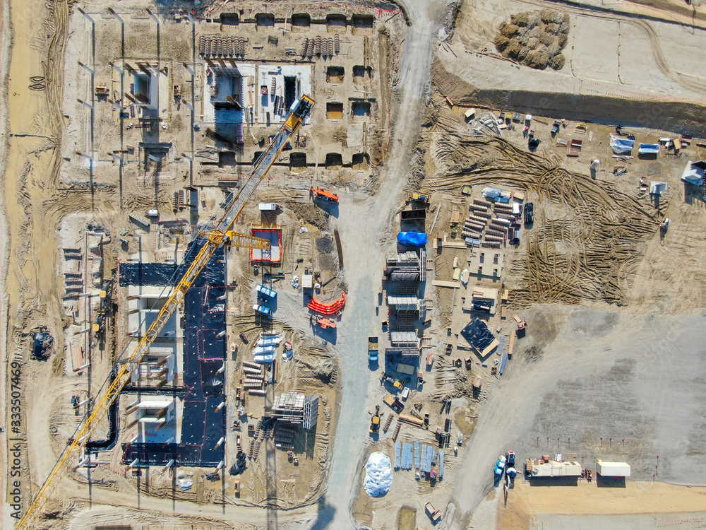 Aerial view of investors and contractors on construction site with crane. New construction site with crane and building materials. San Diego, California, USA. March, 26th, 2020 