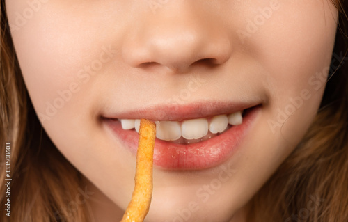 mouth teenage girl eating French fries closeup.