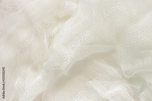 white color woven cotton gauze fabric background texture. close up top view. Selective soft focus. Shallow depth of field. Text copy space.