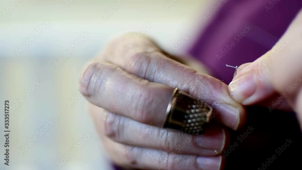 Threading a needle, Closeup HD video of woman's hands pulling thread
