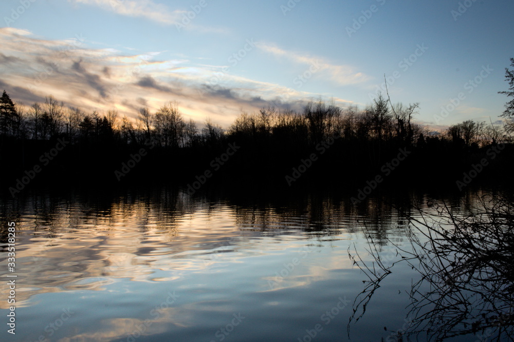 Reflektionen im Wasser vor Sonnenaufgang, glattes Wasser