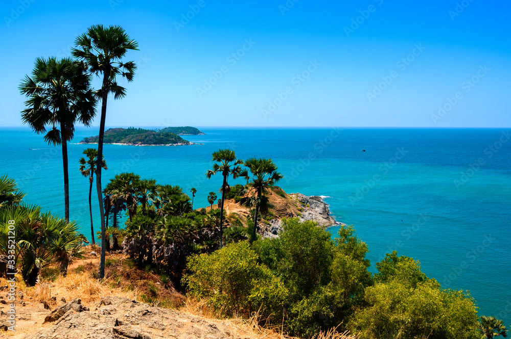 View of the sea, blue sky and palm trees at Promthep Cape in Phuket, southern Thailand.