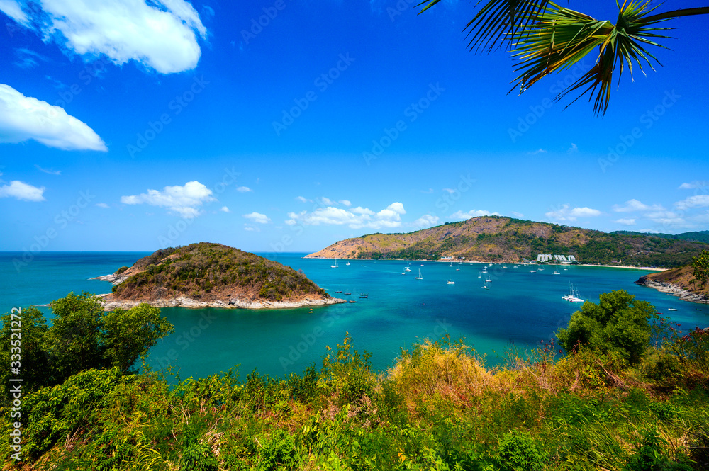 Obraz premium View of the sea, blue sky and palm trees at Promthep Cape in Phuket, southern Thailand.