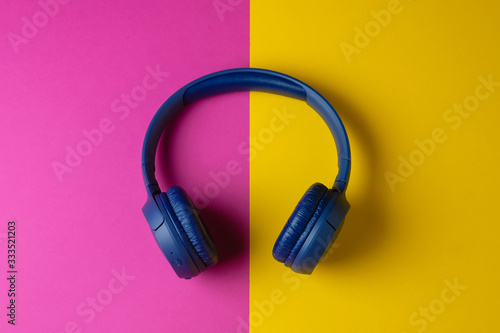 Headphones on a colorful yellow purple background. Webinar or podcast concept.
