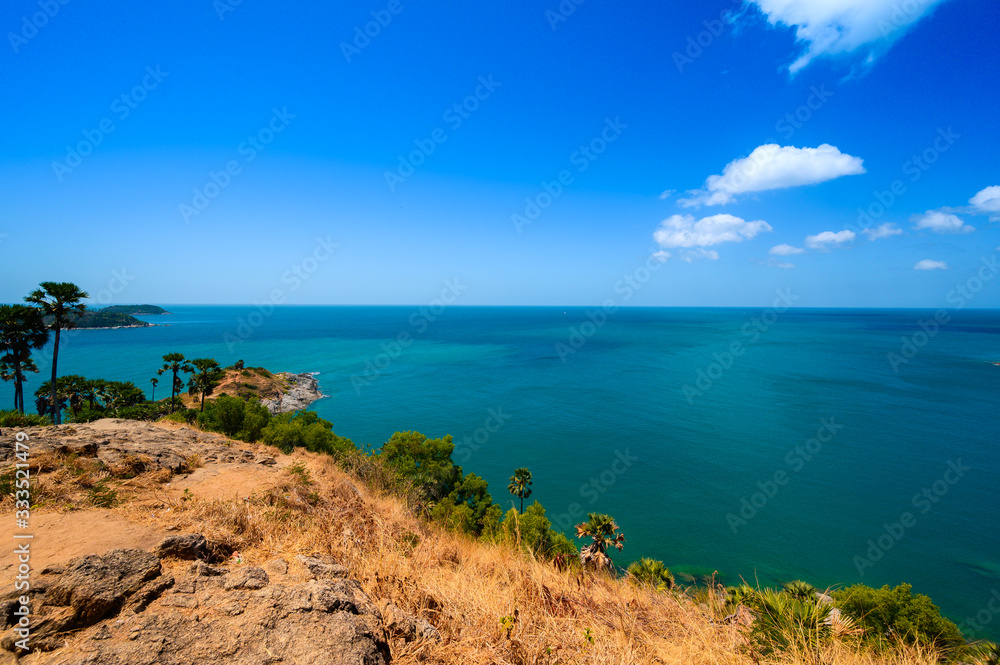 View of the sea, blue sky and palm trees at Promthep Cape in Phuket, southern Thailand.