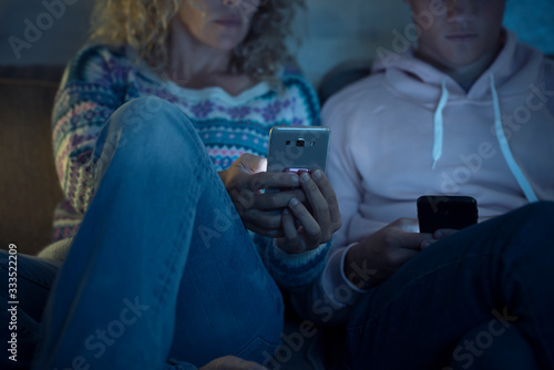 Family and people at home looking for news on phone devices - mother and son with internet connection by night - couple with love distance for connection addicted disease