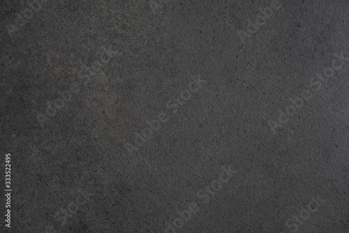 Gray-black granite countertop texture. Black background with splashes of shiny pebbles..