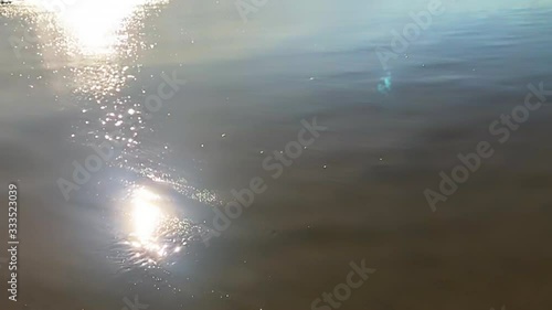 Sunbeams and rainbows on the water surface slow motion