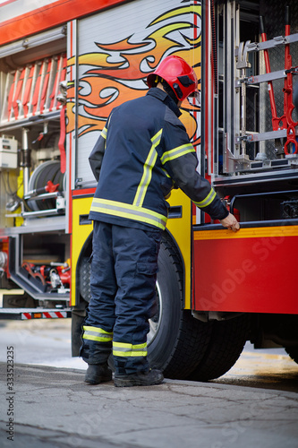 Fireman in uniform in front of fire truck going to rescue and protect. Emergancy servise concept.