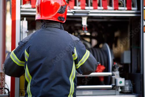 Fireman in uniform in front of fire truck going to rescue and protect. Emergancy servise concept. photo