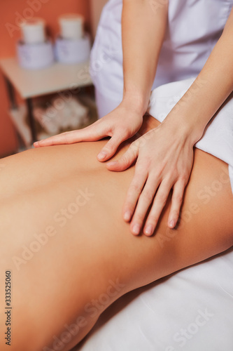 Wallpaper Mural A young girl lies on a table in a spa salon and is covered with a white towel. Female hands massage the back and help relax. Masseur. Torontodigital.ca