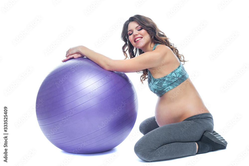 Portrait of a beautiful young pregnant woman exercises with fitball. Working out and fitness, pregnancy concept. Isolated white background. Portrait of a beautiful young pregnant woman exercises with fitball. Working out and fitness, pregnancy concept. Isolated white background.