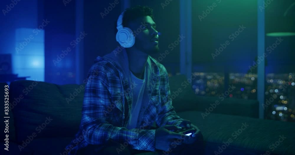 Man playing video games at night in apartment Man playing video games at night in apartment