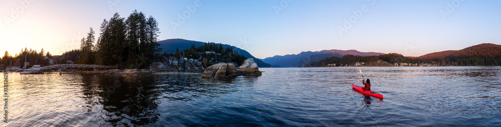 Deep Cove, North Vancouver, British Columbia, Canada. Beautiful Panoramic View of Residential Homes on the Water and girl kayaking during a colorful winter sunset. Panorama Background