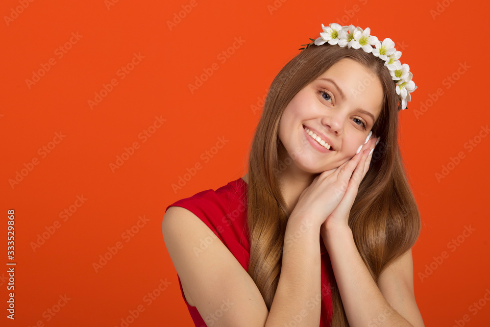 beautiful young woman with a wreath on her head on an orange background