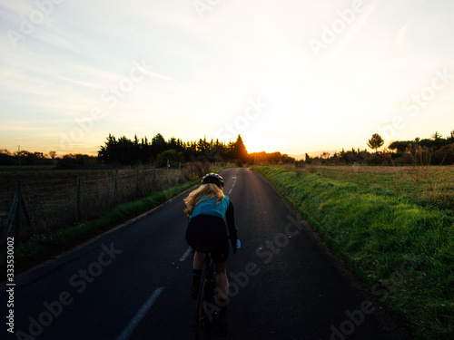 Cyclist in sunset light on bike path near the sea