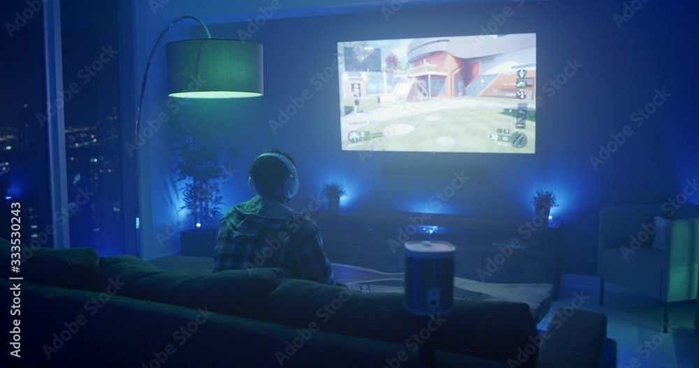 Man playing video games at night in apartment Man playing video games at night in apartment