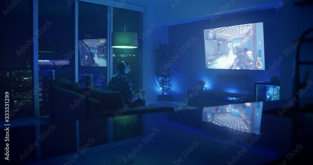 Man playing video games at night in apartment Man playing video games at night in apartment
