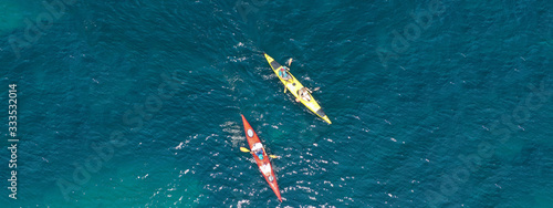 Aerial drone ultra wide photo of young couple canoeing in tropical exotic island bay © aerial-drone