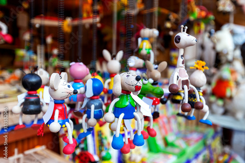 Wooden, colorful animals dog, mouse, giraffe, crocodile, beetle, hanging on black metal springs in market © Jana Krizova