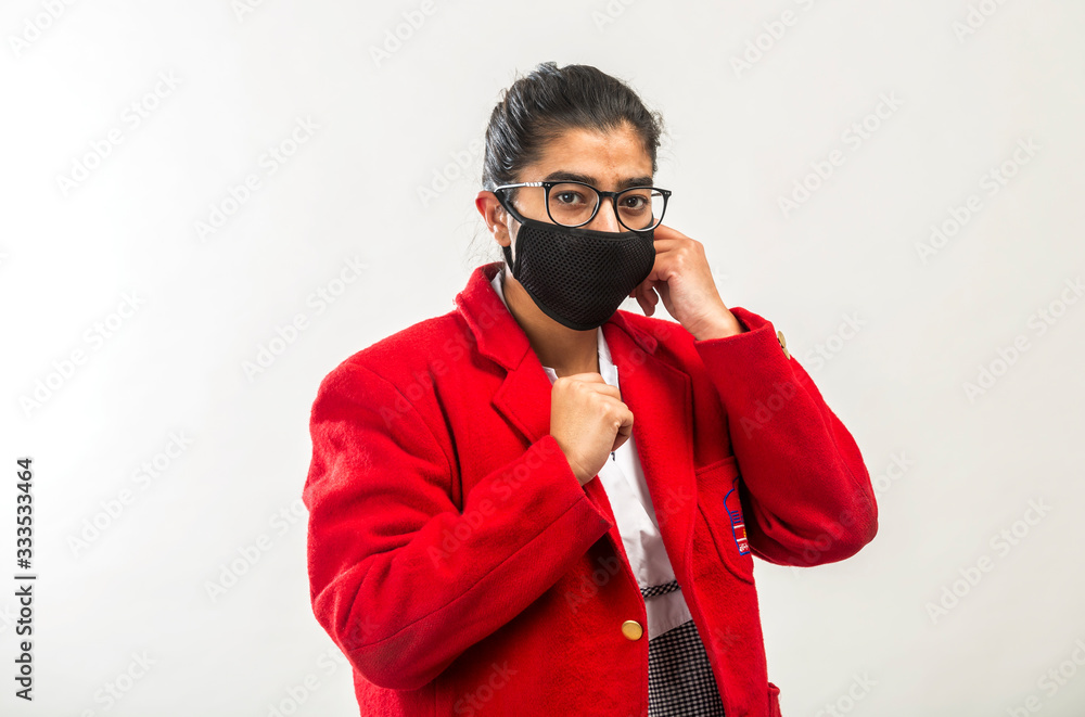 a teenage indian girl in school uniform wearing face mask during corona virus pandemic in India a teenage indian girl in school uniform wearing face mask during corona virus pandemic in India