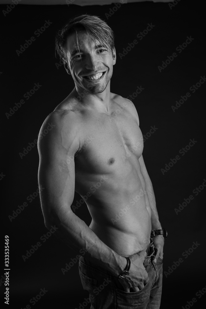 Fototapeta premium black and white studio shoot of strong athletic man on dark background