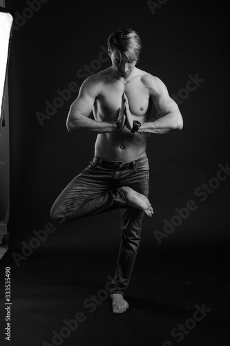 black and white studio shoot of strong athletic man on dark background