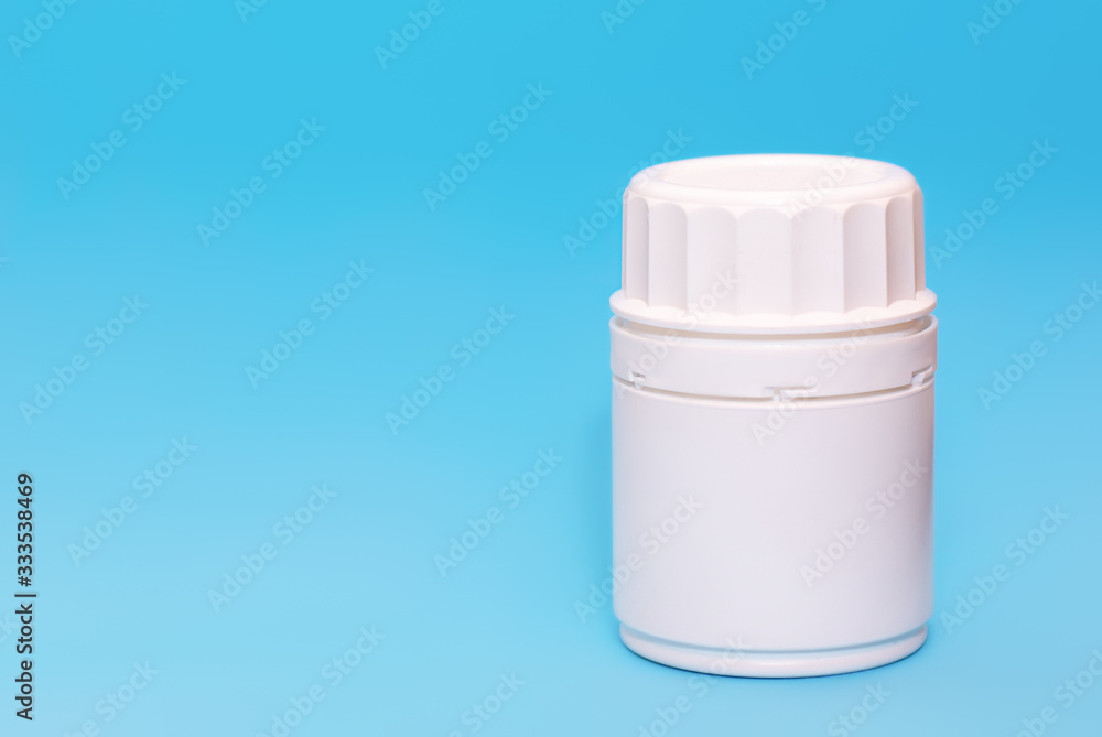 White medical bottle vial on a blue background.Copy space for text White medical bottle vial on a blue background.Copy space for text