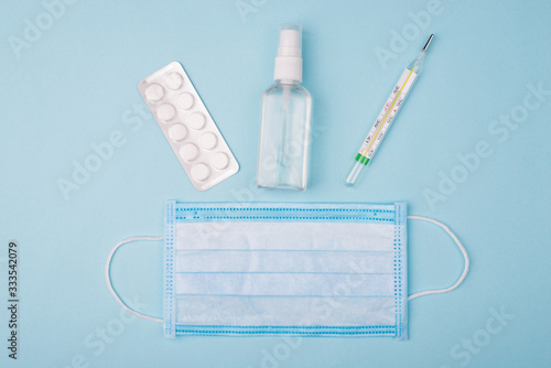 Hygiene and self prevention concept. Top above overhead close up view photo of bottle with liquid thermometer tablets and medical mask isolated over background