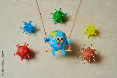 Earth toy on a swing surrounded by viruses