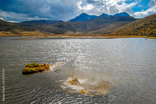 Limpiopungo Lake in the Cotopaxi National Park, on a sunny and cloudy afternoon, with the Ruminahui volcano in the background. Ecuador photo