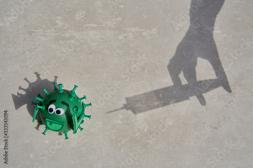 Conceptual shadow of a syringe injecting a vaccine to a green virus