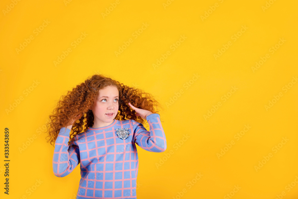 red-haired beautiful girl on a yellow background, beautiful hair