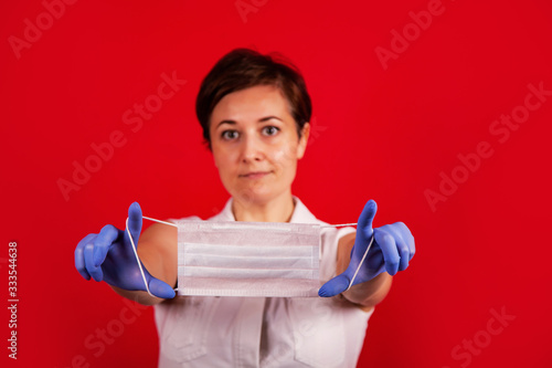 Female hands hold a medical mask. Young professional doctor woman holds a medical mask in her hands. Virus Protection Group.