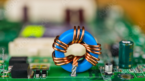 Obraz na plátně Blue toroidal induction coil on green circuit board