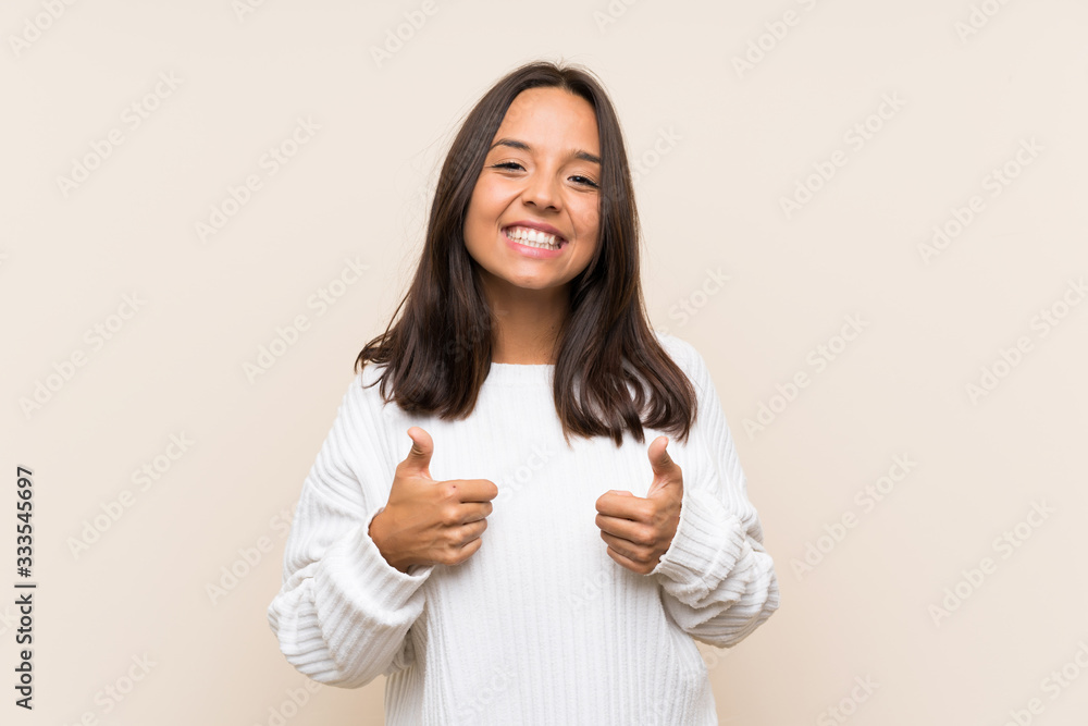 Young brunette woman with white sweater over isolated background giving a thumbs up gesture Young brunette woman with white sweater over isolated background giving a thumbs up gesture