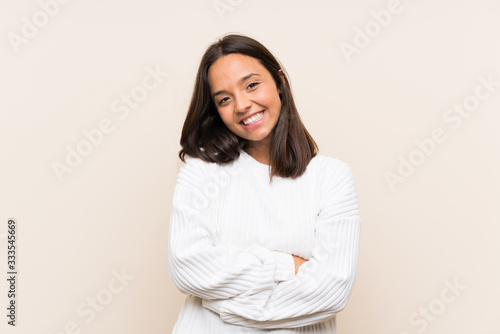 Young brunette woman with white sweater over isolated background laughing