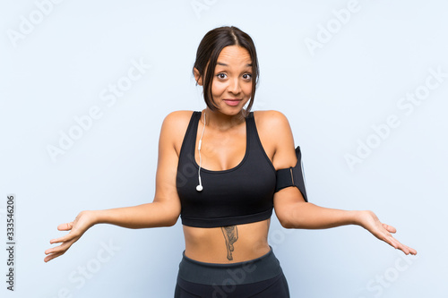Fototapeta Naklejka Na Ścianę i Meble -  Young sport girl over isolated blue background with shocked facial expression