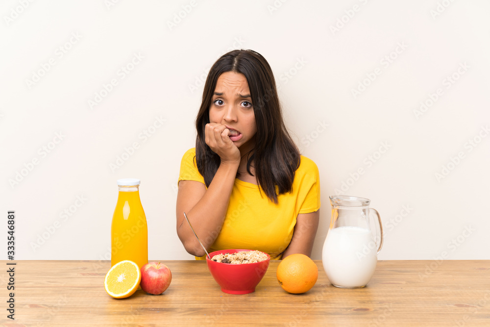 Young brunette girl having breakfast milk nervous and scared Young brunette girl having breakfast milk nervous and scared
