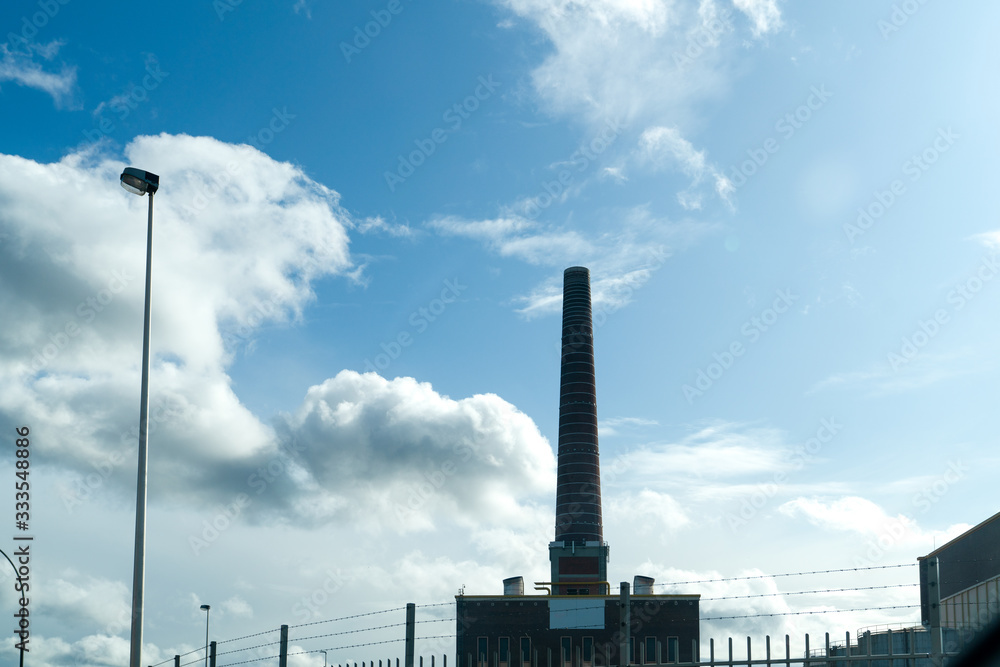 Old factory chimney on blue sky background.