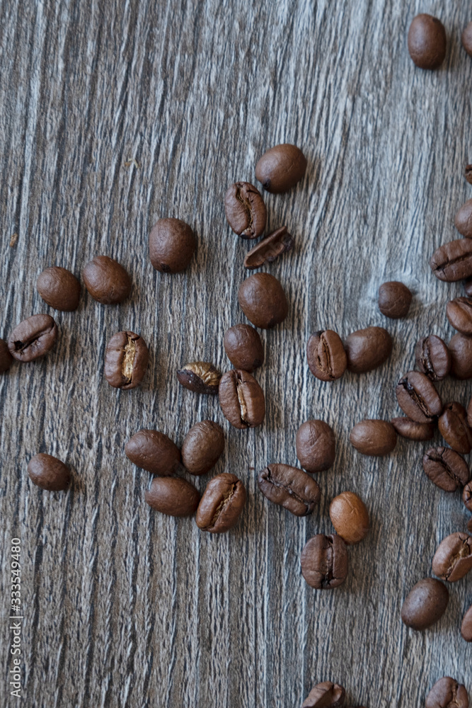 Coffee beans scattered on an open table. View from above. Coffee beans scattered on an open table. View from above.